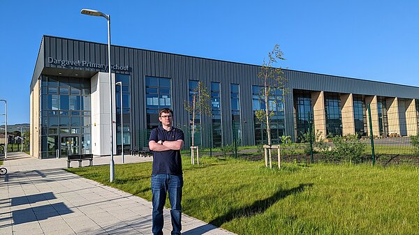 Grant Toghill standing outside Dargavel Primary with arms crossed